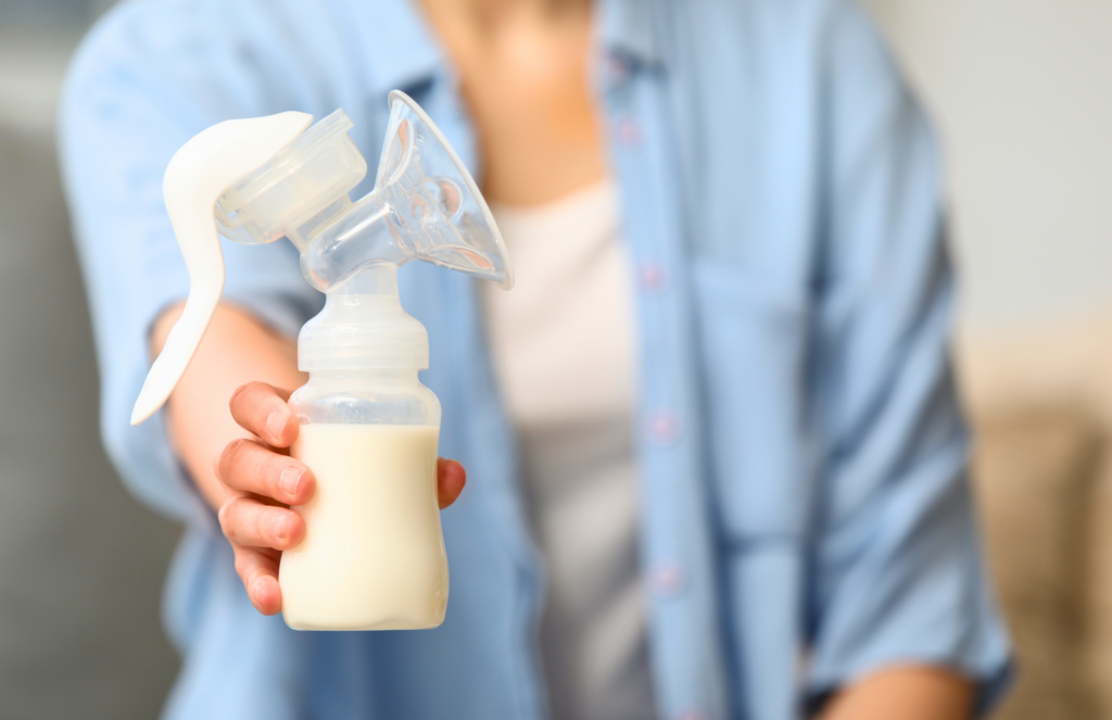 woman holding breast pump bottle with milk for pumping and traveling