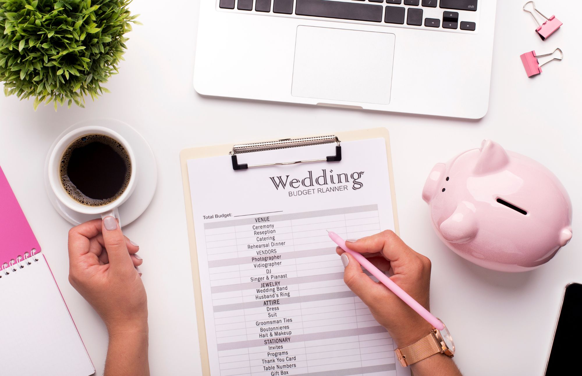 Person writing on a Wedding Budget Planner