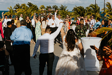 Crowd welcomes wedding couple at cocktail hour at a destination wedding in Mexico