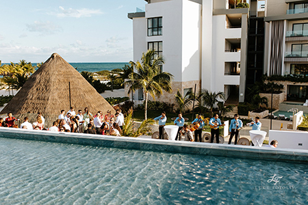 view of the cocktail hour from above showing ocean, palm trees, and the Mariachi band