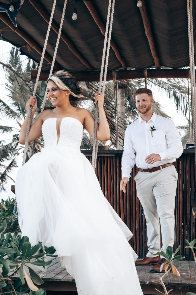 Destination wedding couple on a swing at an all inclusive resort