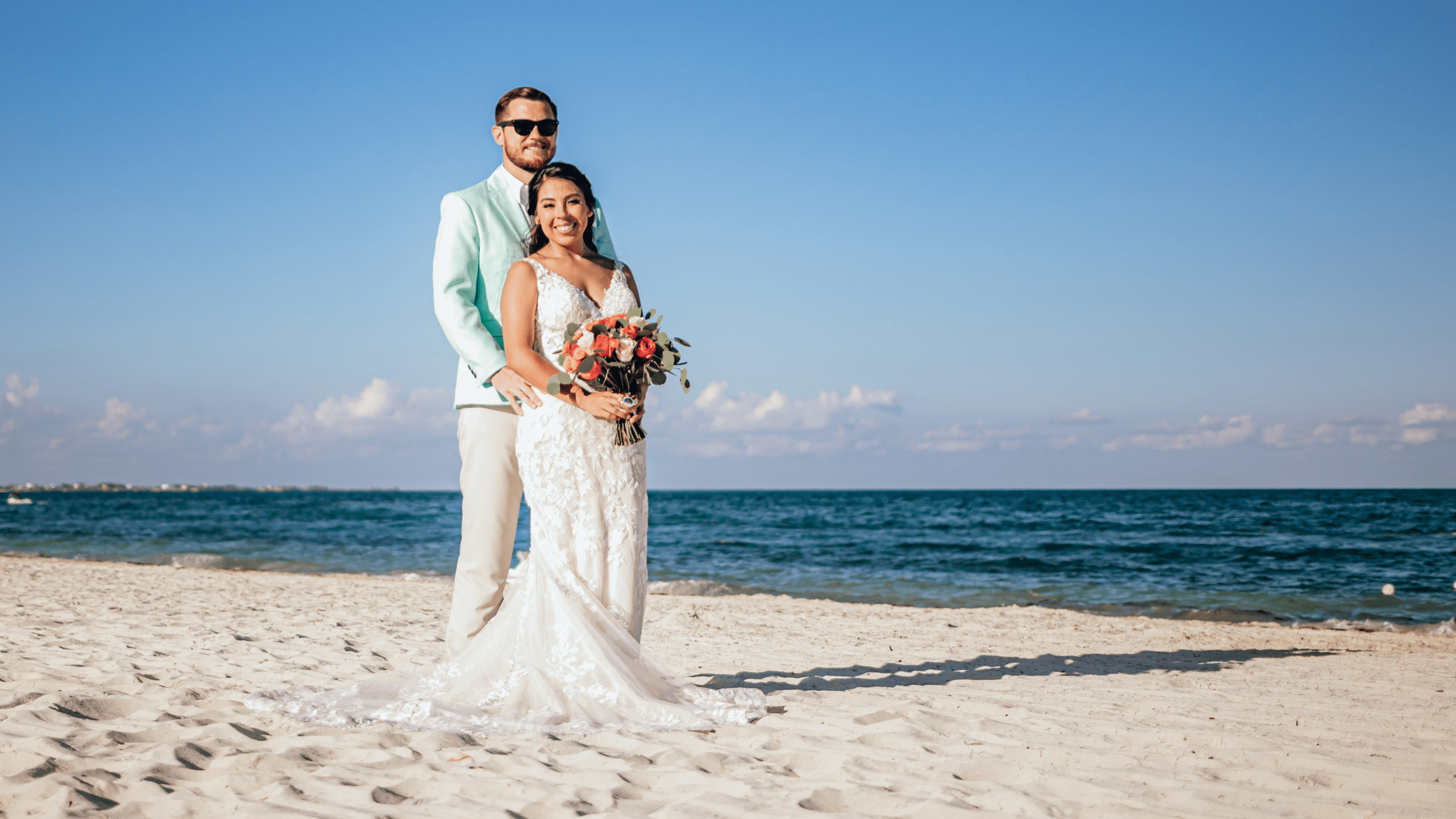 wedding couple on beach with ocean in the background