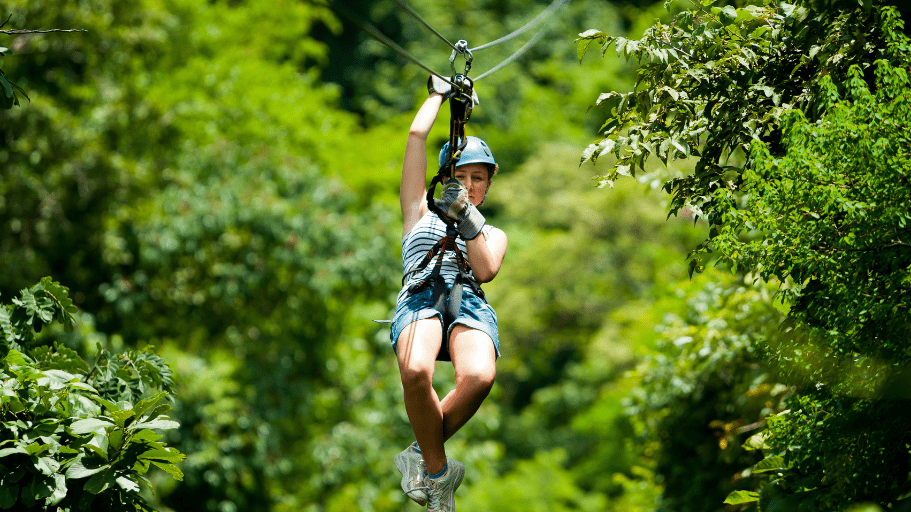 woman ziplining through costa rican forest