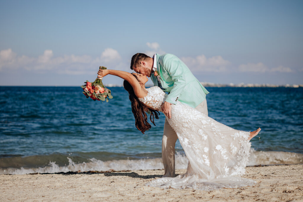 bride and groom share a kiss on the beach-budgeting for a destination wedding