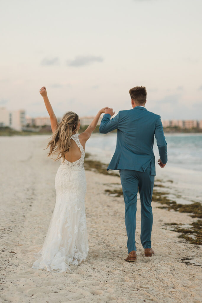 budgeting for a destination wedding- happy couple walking down the beach