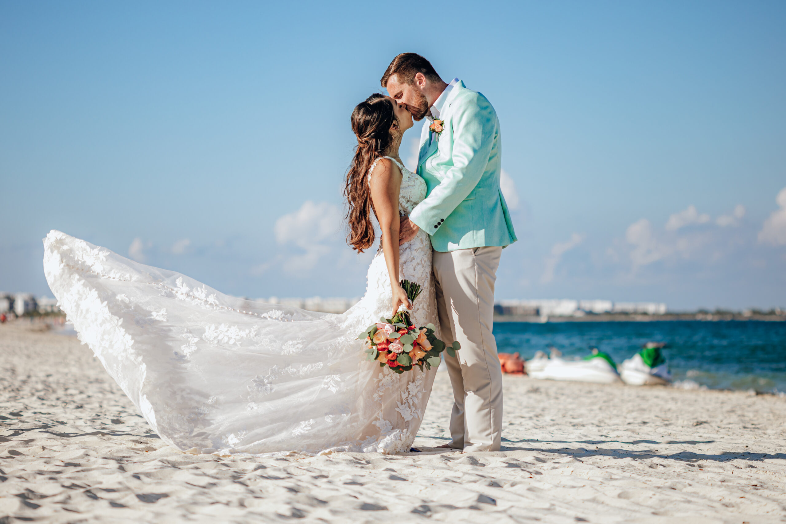bride and groom kiss on the beach