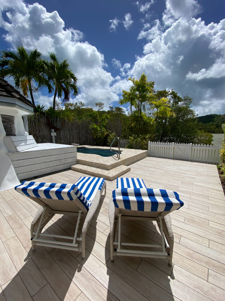 white and blue striped outside loungers on a desk near a pool
