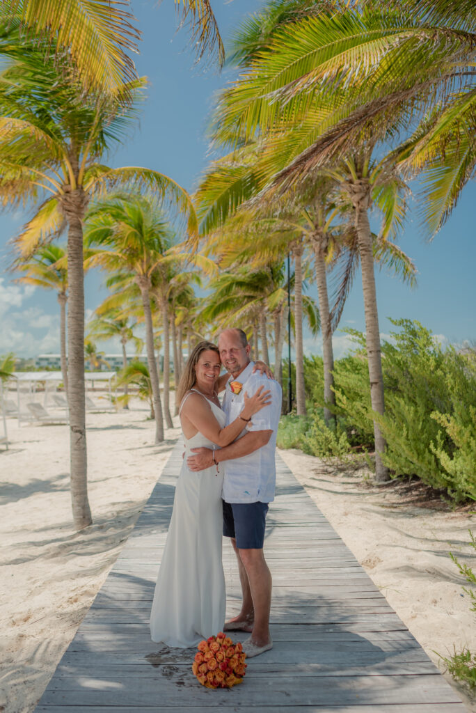 bride and groom posing with palm trees at the best destination wedding locations