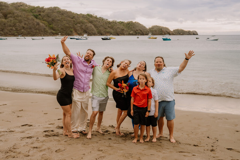 Friends and bridal party making silly faces on the beach, showing the playful side of being a destination wedding guest.