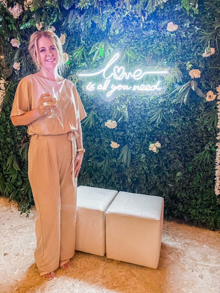 Smiling wedding planner at a stylish indoor backdrop—perfect for destination weddings not on the beach.