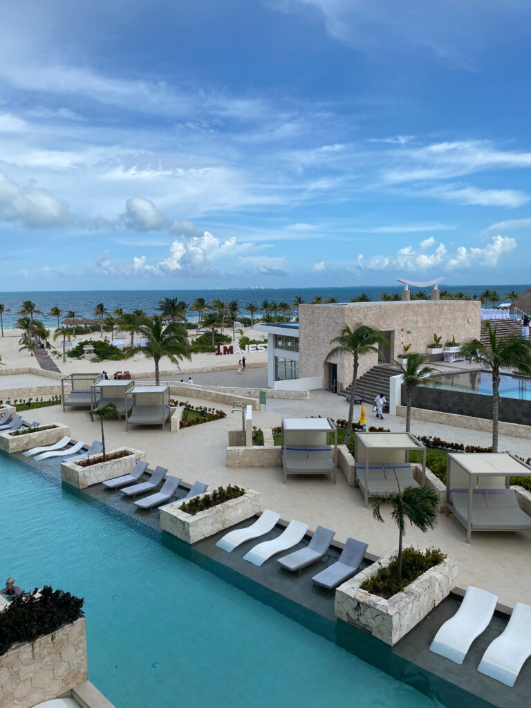 Modern poolside lounge area with cabanas and palm trees, ideal for the best destination wedding resorts.