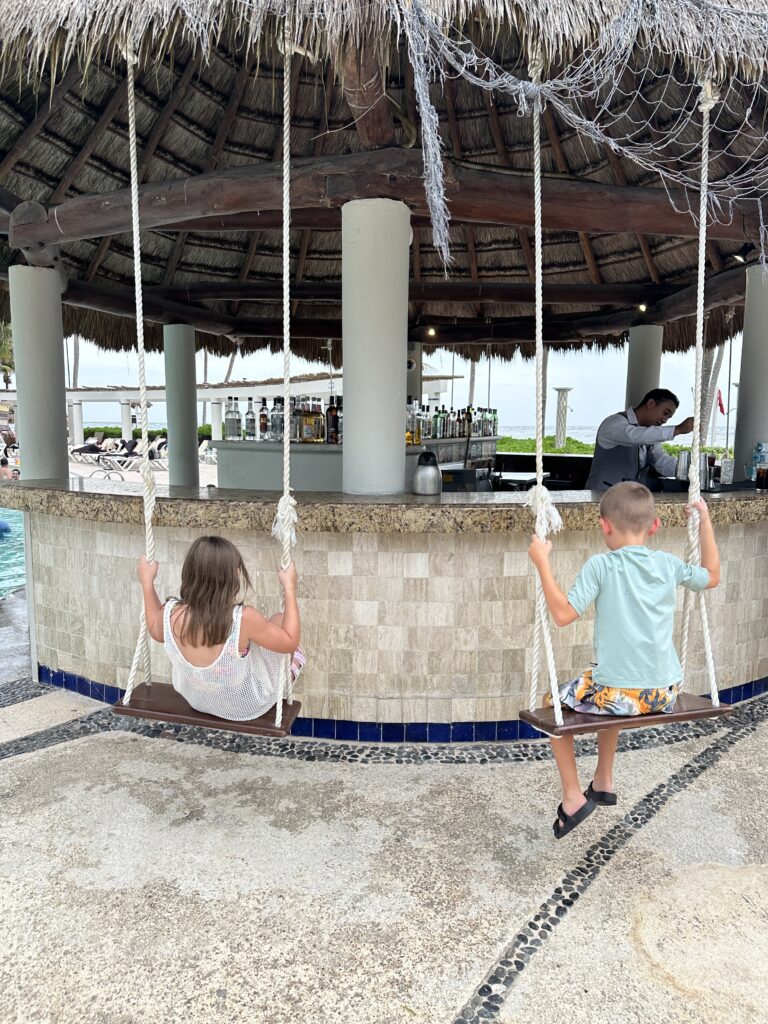 Kids enjoying the bar swings on a family vacation to mexico 