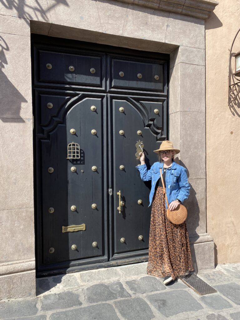 Woman in front of a decorative door
