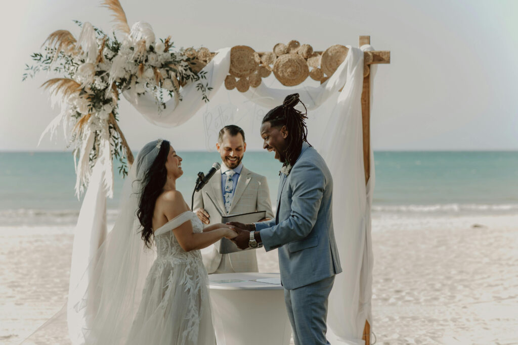 Beach wedding ceremony with natural floral arch and sustainable details showcasing eco friendly wedding ideas.