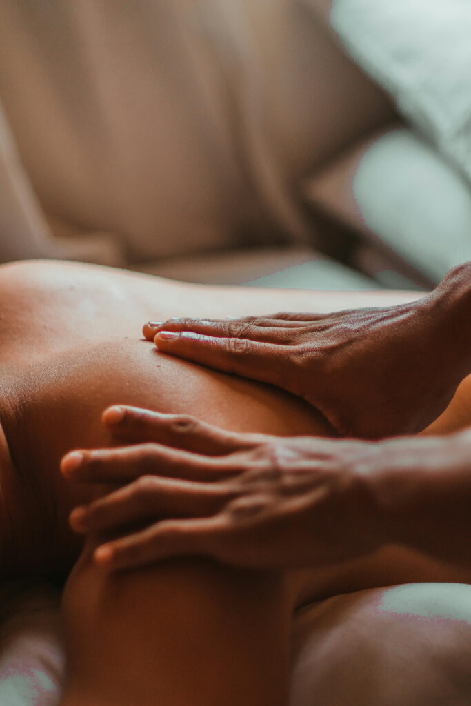 Close-up of a relaxing back massage at a spa, showing hands gently pressing into the skin.