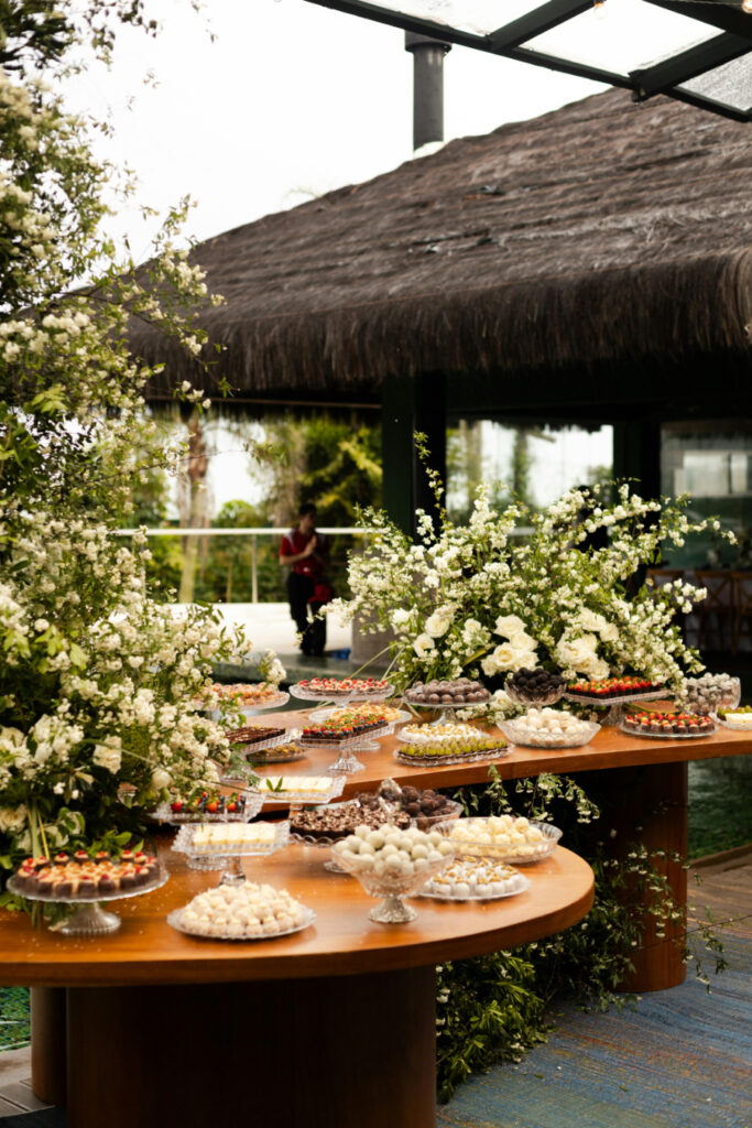 Lush dessert table featuring assorted sweets and elegant white florals, perfect for a garden or outdoor wedding.