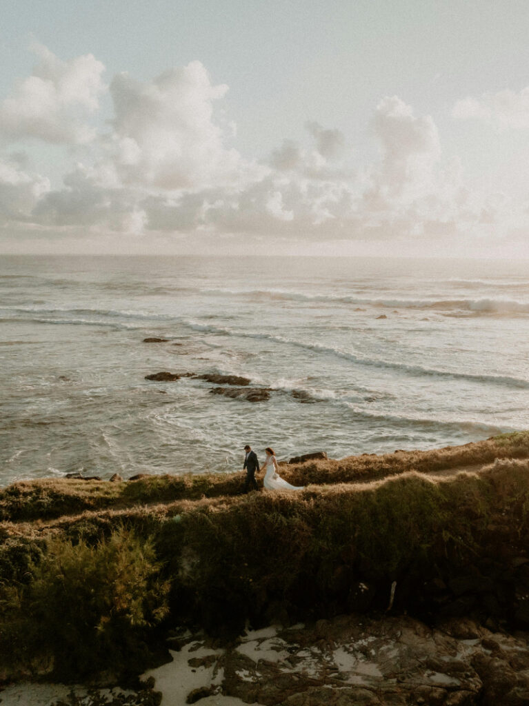 Bride and groom walk along Mexico coastline, capturing a romantic moment from their wedding guest experience guide.