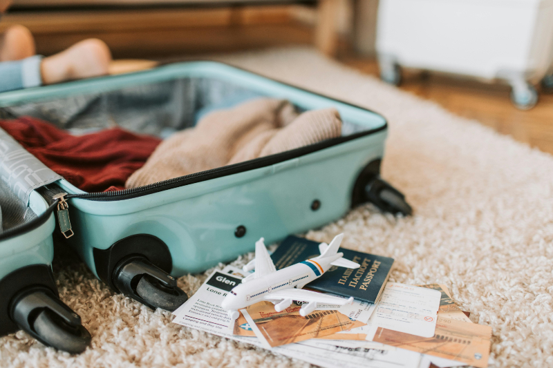 Open suitcase with clothes, passport, and boarding passes, showing how to avoid honeymoon travel mistakes when packing.