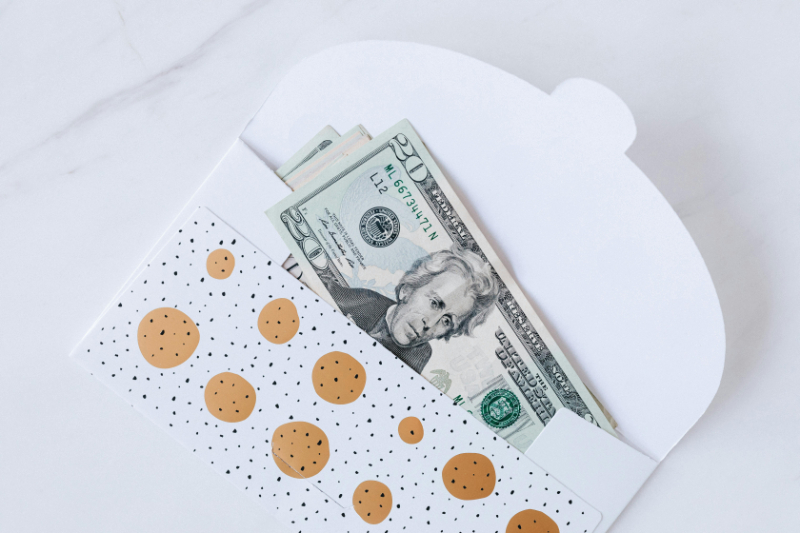 Cash inside a patterned envelope, symbolizing budget planning for a luxe destination wedding.