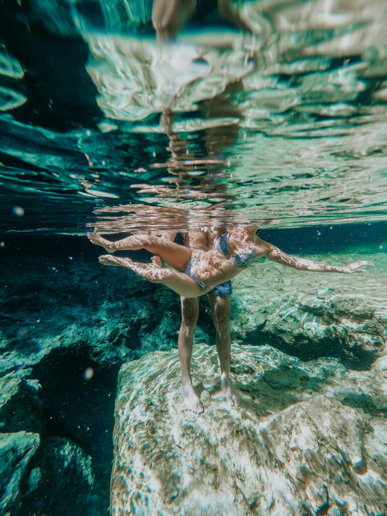 Couple swimming underwater in clear blue water, capturing romantic island vibes - How to Pick the Right Type of Honeymoon