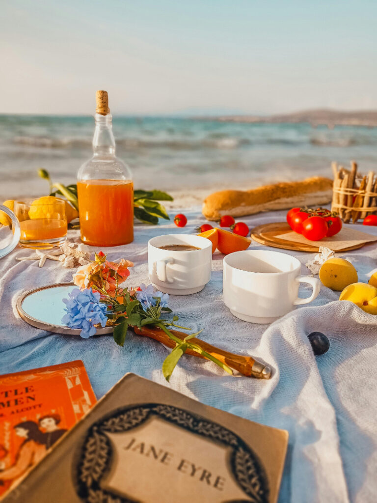 Romantic beach picnic setup with coffee, juice, and fresh fruit- How to Pick the Right Type of Honeymoont.
