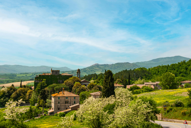 Europe honeymoon countryside view with rolling hills, charming village, and lush green landscapes.