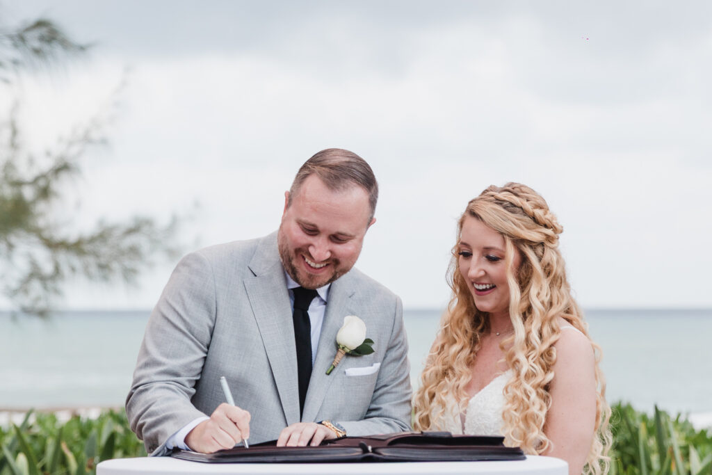 bride and groom signing marriage certificate during their ceremony