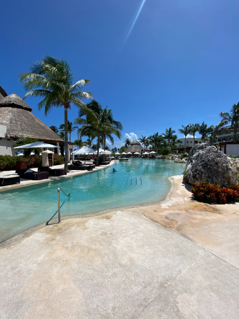 Riviera Maya wedding resorts with tropical pool, palm trees, and beachfront luxury ceremony setting