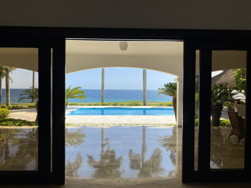 Oceanfront villa view with open doors and infinity pool, ideal for luxury destination wedding ideas