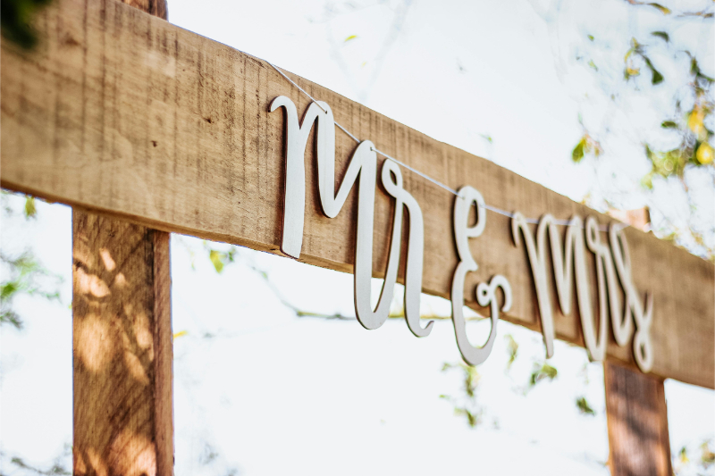 Elegant “Mr & Mrs” wooden wedding sign on beach setup, simple decor for a stress free wedding atmosphere