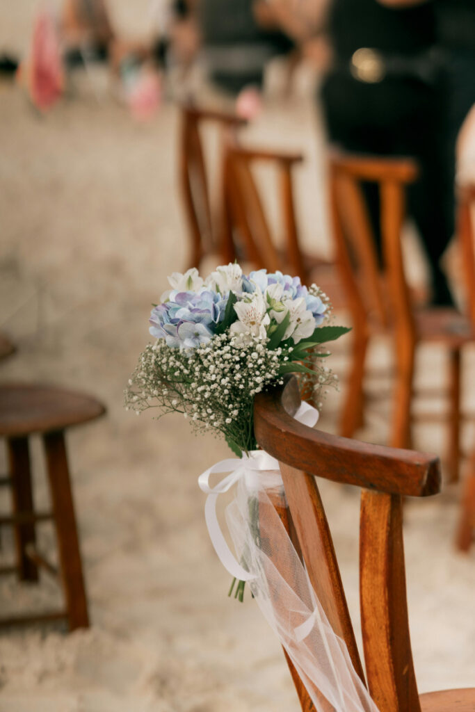Wedding chair floral decor on beach, simple ceremony setup detail, destination wedding budget breakdown inspiration