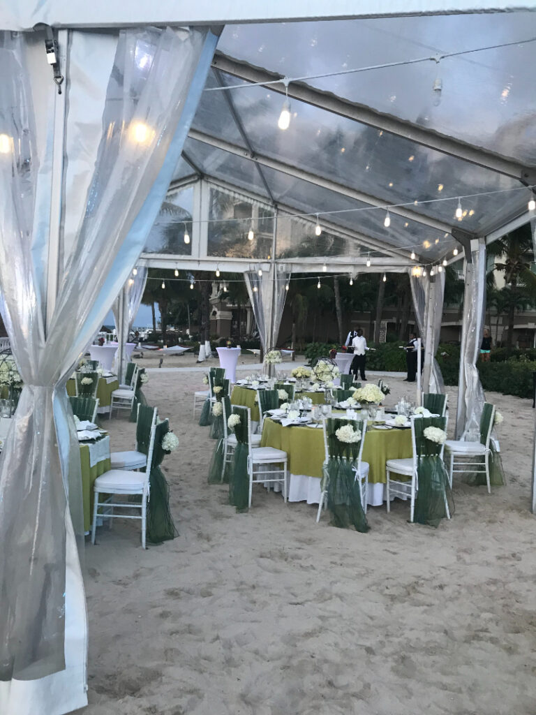 Elegant beach reception setup under a tent featured in Jamaica wedding packages.