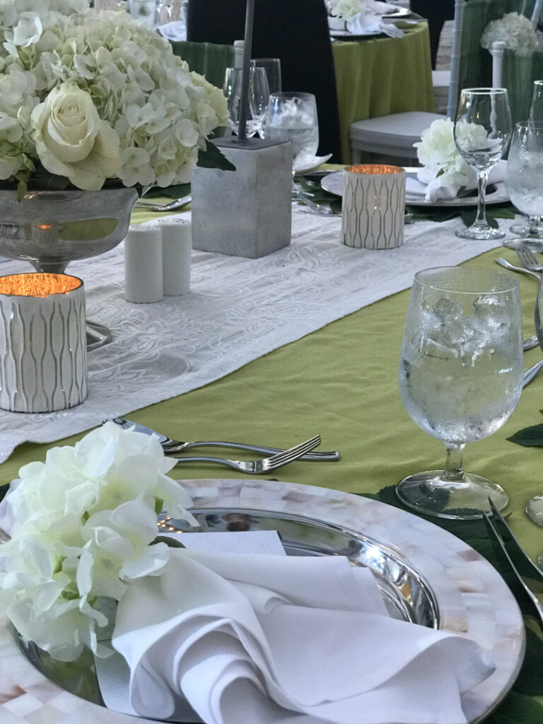 Elegant wedding reception table setting with floral décor, candlelight, and place settings.
