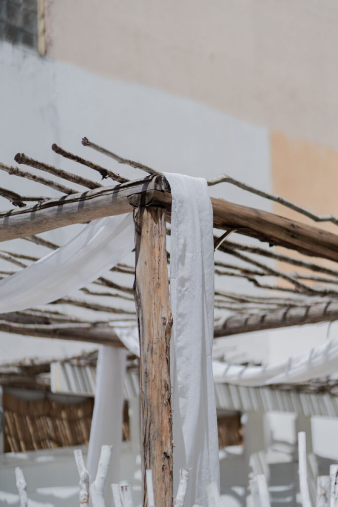 Cancun vs Riviera Maya wedding venue with white fabric accents and rustic beachfront architecture